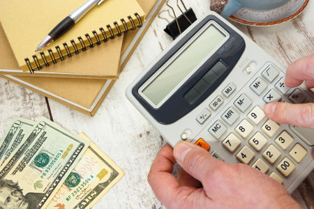 Money next to a calculator and office supplies. Financial concept.の写真素材