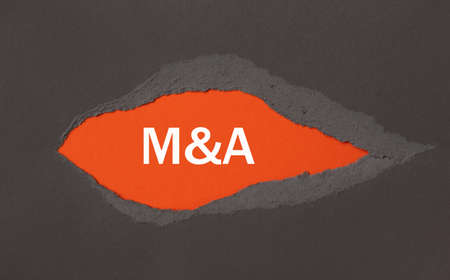 M and A - Merger and Acquisition - the inscription appears behind the torn paper.の写真素材