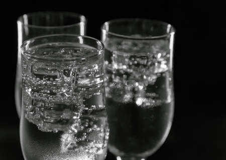 A refreshing, cold drink in glasses with ice on a black background.の写真素材