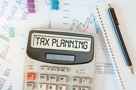 TAX PLANNING word on calculator. Business and tax concept. Time to pay tax in year.の写真素材