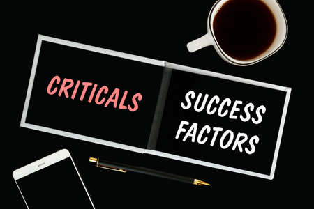 A notebook with black pages, smartphone and a cup of coffee on a black background. The inscription...