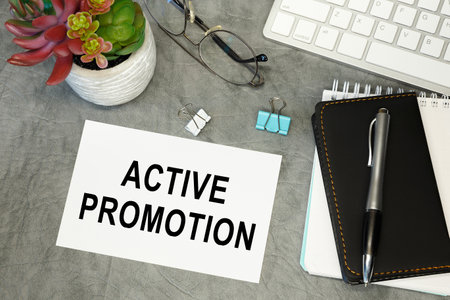 Active promotion - lettering on paper on the desktop, notepad, pen and keyboard. Concept photo of the advantage.の写真素材