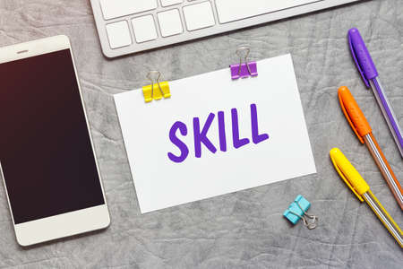 A paper note with the text of the SKILL, keyboard and a smartphone.の写真素材
