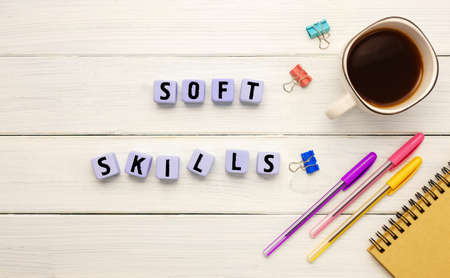 Cubes with the abbreviation SOFT SLILLS ,, coffee and office supplies on a white backgroundの写真素材