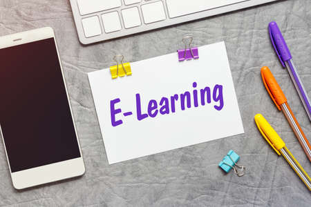 A paper note with the text of the E-LEARNING, keyboard and a smartphone.の写真素材