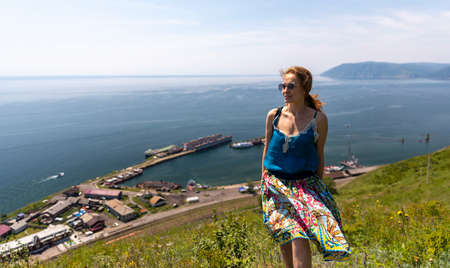 Lake Baikal, beautiful tourist girl on the background of Port Baikalの写真素材