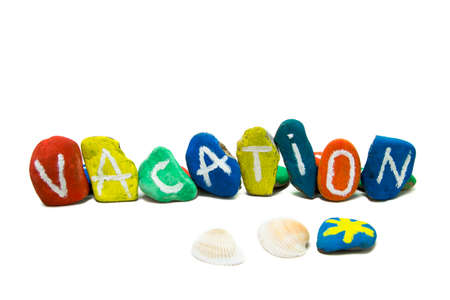Colored rocks with vacation text and seashells on white backgroundの写真素材
