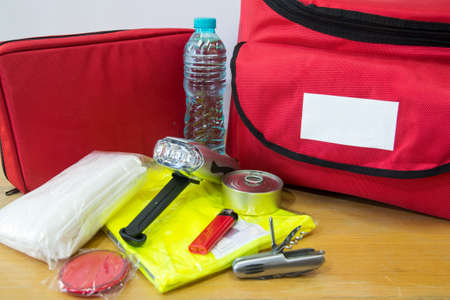 Emergency kit for survival in case of disaster including water, first aid kit, lighter, bags, utility knife and othersの写真素材