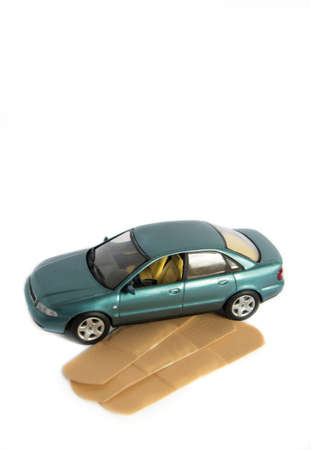 A light blue car near some bandages/patches on white.の写真素材