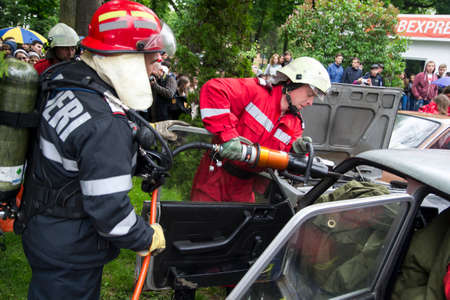 A firefighter cutting car that was involved in accident - Romanian National Emergency Exerciseのeditorial素材