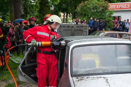 A firefighter cutting car that was involved in accident - Romanian National Emergency Exerciseのeditorial素材
