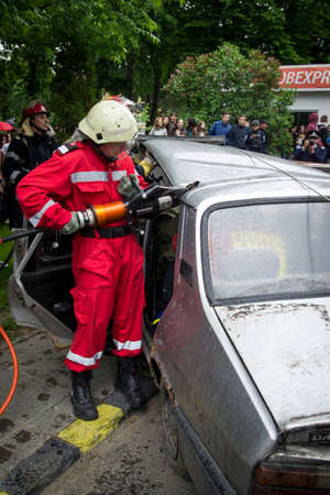 A firefighter cutting car that was involved in accident - Romanian National Emergency Exerciseのeditorial素材
