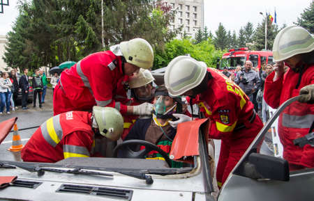 Firefighter rescuing wounded young man in car accident - Romanian National Emergency Exerciseのeditorial素材
