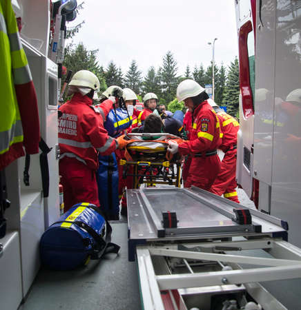 Firefighters transporting victim from car accident into ambulance. Romanian National Emergency Exerciseのeditorial素材