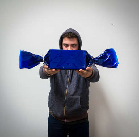 Creepy young man with hood giving candy.の写真素材