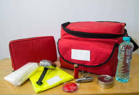Emergency kit for survival in case of disaster including water, first aid kit, lighter, bags, utility knife and others.の写真素材