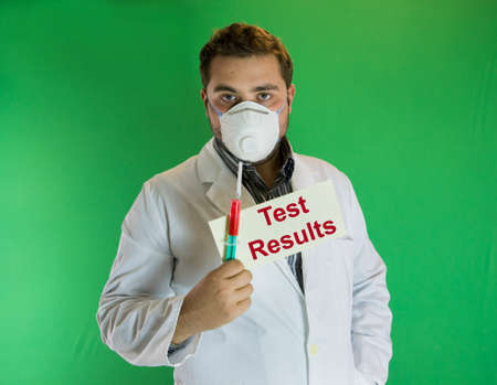 Young doctor holding syringe with blood sample and envelope with test resultsの写真素材
