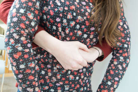 A young woman learning how to do the Heimlich maneuver which is used in case of choking. (Step 1)の写真素材