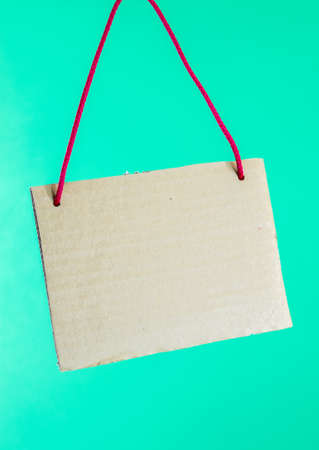 Cardboard sign. Blank cardboard sign with red lace on mint green background.の写真素材