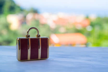 Miniatural brown luggage or purse suitable for travel concept. Blurry background.の写真素材
