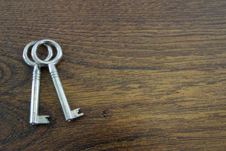 Two vintage keys on a wood texture background.の写真素材