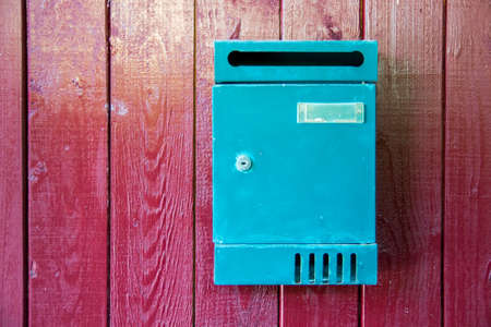 Green mailbox on wood wall painted redの写真素材