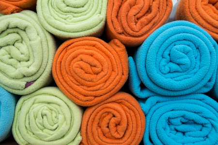 Pile of colorful blankets made from fleece, all rolled up.の写真素材