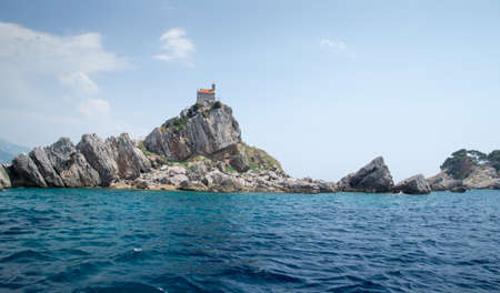 Small church on a cliff in Budva Bay in Montenegro. Cliffs rising from the sea.の写真素材
