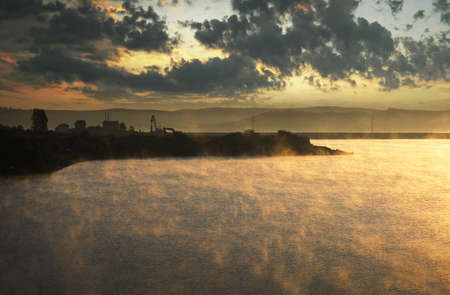 fog rising from cold lake at morning and looking like fire の写真素材