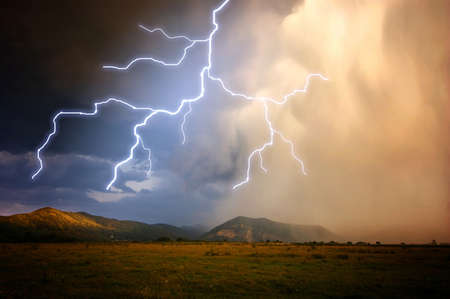 Lightning over the mountains with heavy rain and clouds