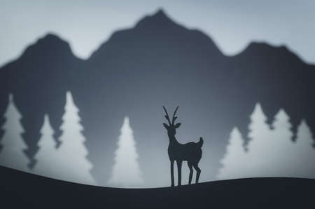 Deer, mountain and pine tree paper made landscape. Handmade winter pop-up postcardの写真素材