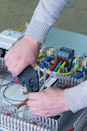 man cleans the wire for assembling electric Cabinetの写真素材