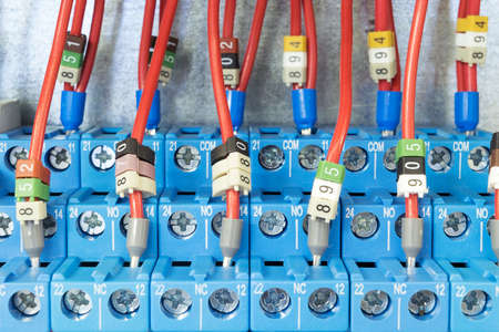 Several intermediate relay blue wires are connected according to the scheme. The relay is mounted on the rail on the circuit Board in the electrical Cabinet. The markings on the wires and caps.の写真素材