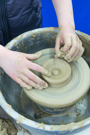 The master teaches the child, a student of pottery. Helps to make out of clay on a Potter's wheel a...