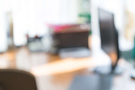 The blurred image of the office. Not in focus. The office is a table, on the table is the monitor or computer or laptop. Are paper, are folder.の写真素材