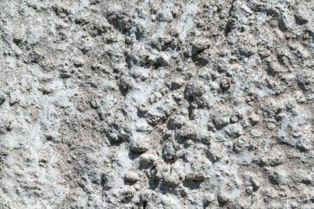 A piece of concrete wall with pebbles. In concrete inclusions of small and large pebbles of gray and...