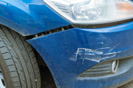 The car after the accident with a broken bumper. Between the fender and the bumper view of the crack. On the bumper are visible dings and scratches.の写真素材