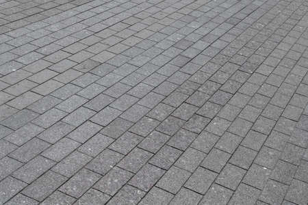 Area or walkway made of granite or marble rectangular tiles grey color. Tiles laid out in a line,...
