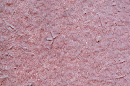 The texture of the walls of wood painted with red paint. Visible cracks, bumps and depressions. Under the paint visible old layer of paint.の写真素材