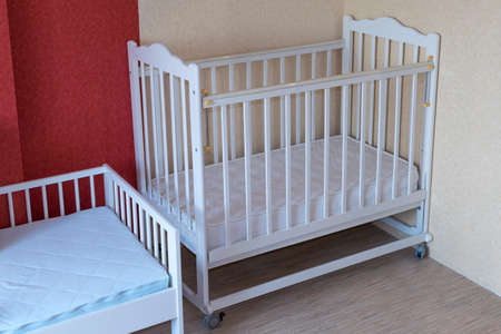 The nursery has two Cribs. One cot for toddlers and one for older children. Crib white. On the...