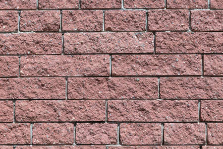 The wall and the bricks are red or brown. Masonry of bricks laid horizontally. The joints between the bricks with cement.の写真素材