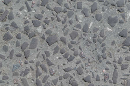 Old road paved with stones or cobbles. The stones are smoothed, chamfered, rolled. Road with cracks. Stones of different sizes, large and small.の写真素材