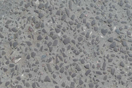 Old road paved with stones or cobbles. The stones are smoothed, chamfered, rolled. Road with cracks. Stones of different sizes, large and small.の写真素材