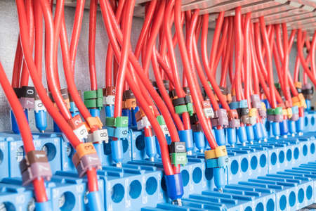 Many intermediate relays installed in a row. They are connected with many wires red with marking. Wires connected to the relay via cable lugs. Markings of different colors with numbers.の写真素材