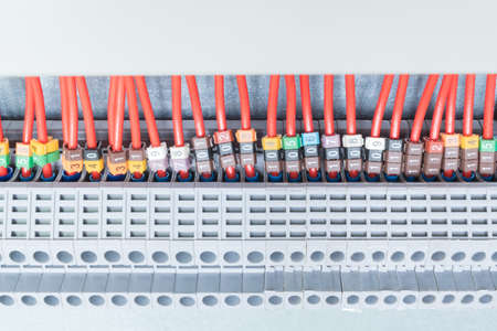 Lot electrical feedthrough terminals, arranged in a row. To them are attached the electric wires marked. Marking with numbers. Marking of a different color. The wires go into the cable channel.の写真素材