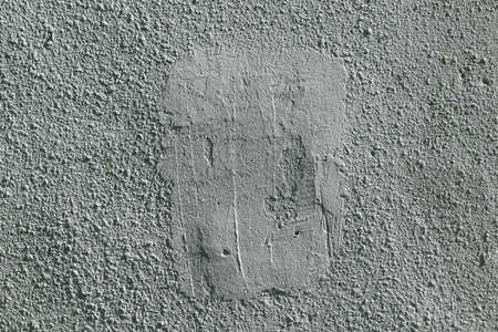 Rough wall covered with plaster and painted. In the center part of the wall plastered with cement and painted. Wall clean. Plaster grainy with many small projections and depressions.の写真素材