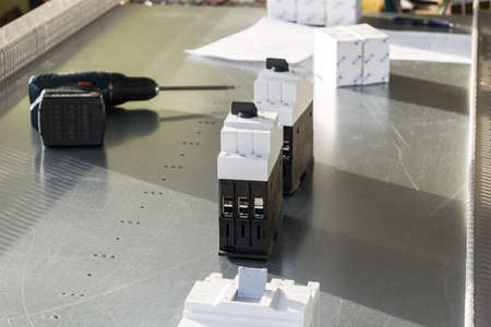 On mounting panel power circuit breaker, circuit breakers for motor protection, screwdriver, box and list. Preparation and placement on a circuit Board for Assembly of a new electrical Cabinet.の写真素材