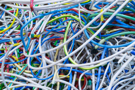 The bunch of electric wires of different colors are very much intertwined. On tangled wires is wire-end ferrules and markings. Chaos, confusion, tangle.の写真素材