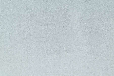 Wall grungy covered with plaster and painted white. Clean surface with pimples, small bumps and stripes. Flat wall of the building.の写真素材