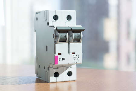 Two-pole modular circuit breaker is on the table, front view. Electrical switch to protect home wiring and appliances. On the front there is a status indicator on off.の写真素材
